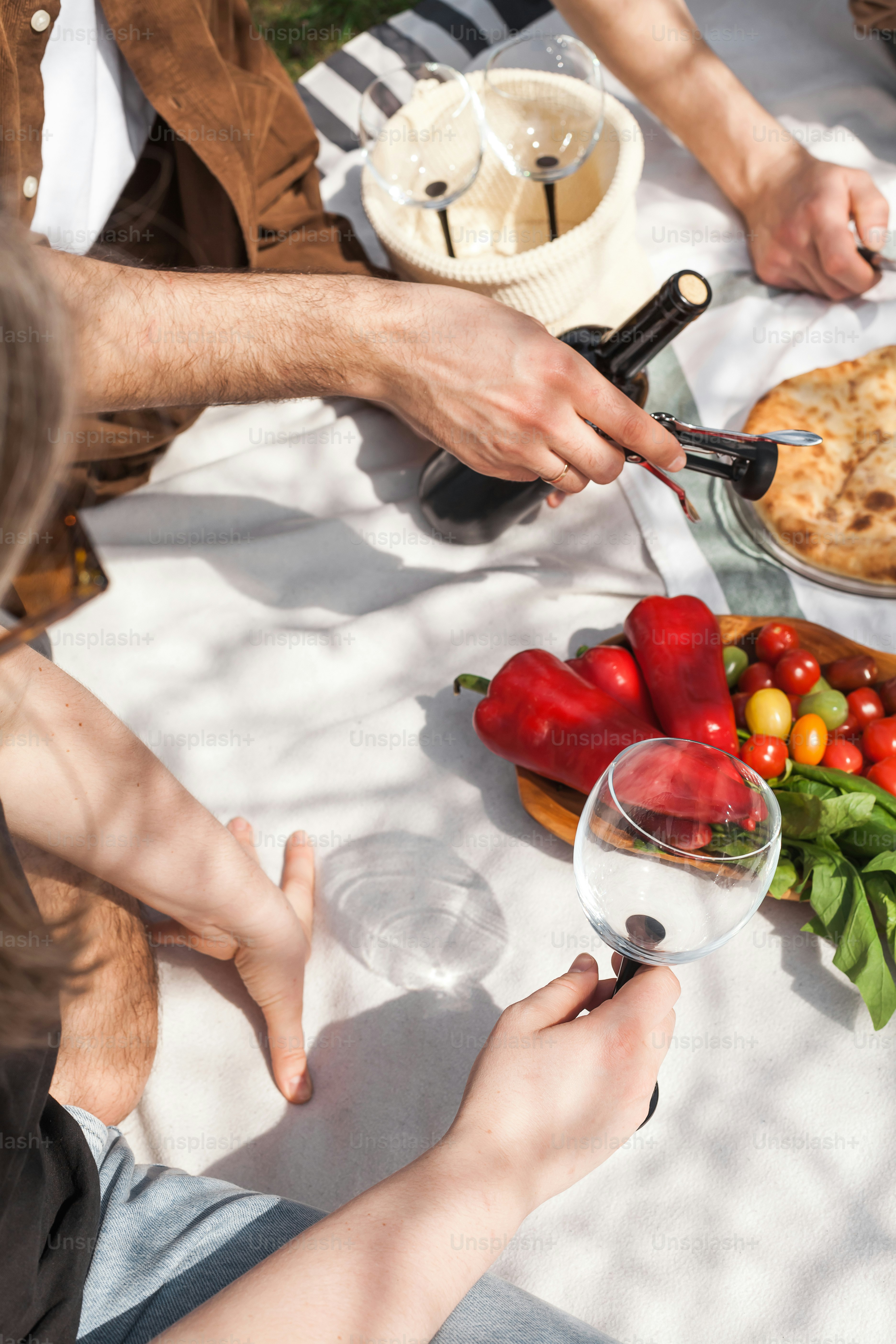 A group of people sitting around a table with food and wine photo ...