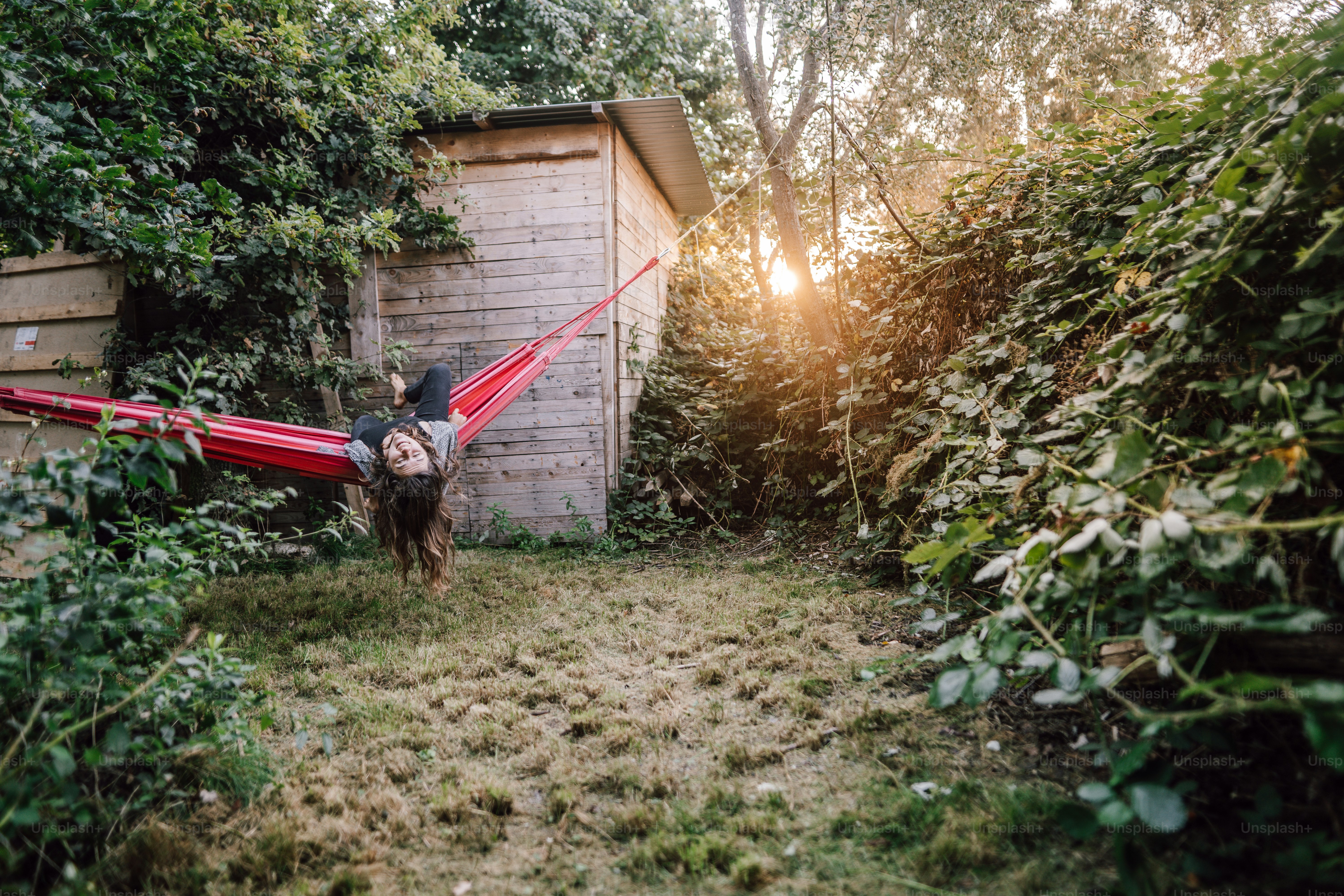 a person in a hammock in a yard