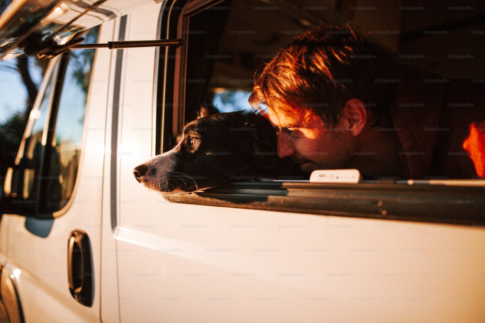Ein Mann und sein Hund schauen aus dem Fenster eines Lieferwagens