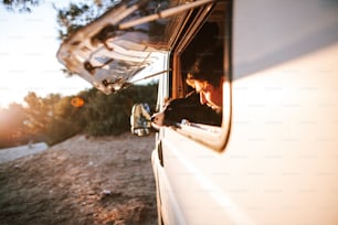 uma mulher está olhando pela janela de um veículo