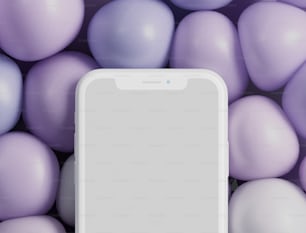 Un teléfono celular blanco rodeado de bolas moradas