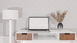 un computer portatile seduto sopra una scrivania bianca