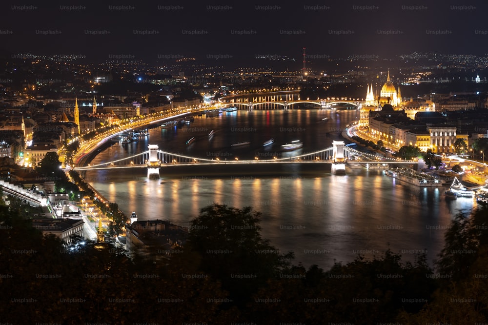 uma vista noturna de uma cidade e uma ponte