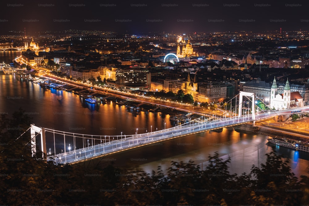 uma vista noturna de uma cidade e uma ponte