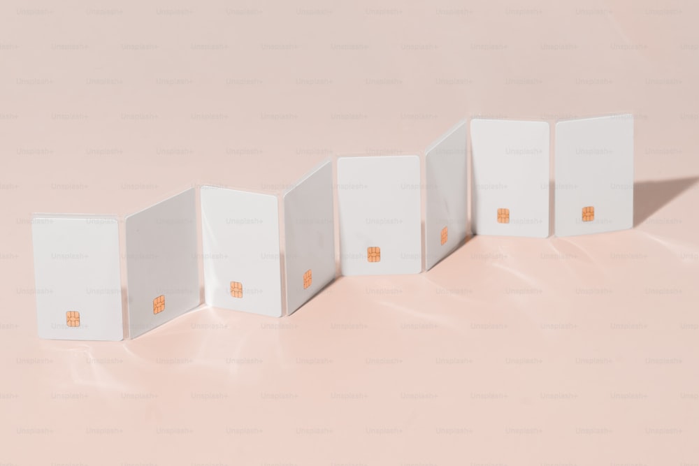 a row of white boxes sitting on top of a pink surface