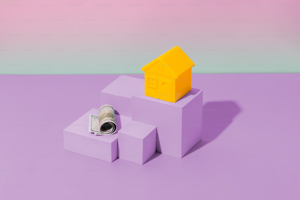 Una piccola casa seduta in cima a un blocco viola