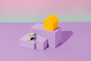 Una pequeña casa sentada encima de un bloque púrpura