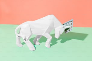 a paper mache of a white bull on a green and pink background
