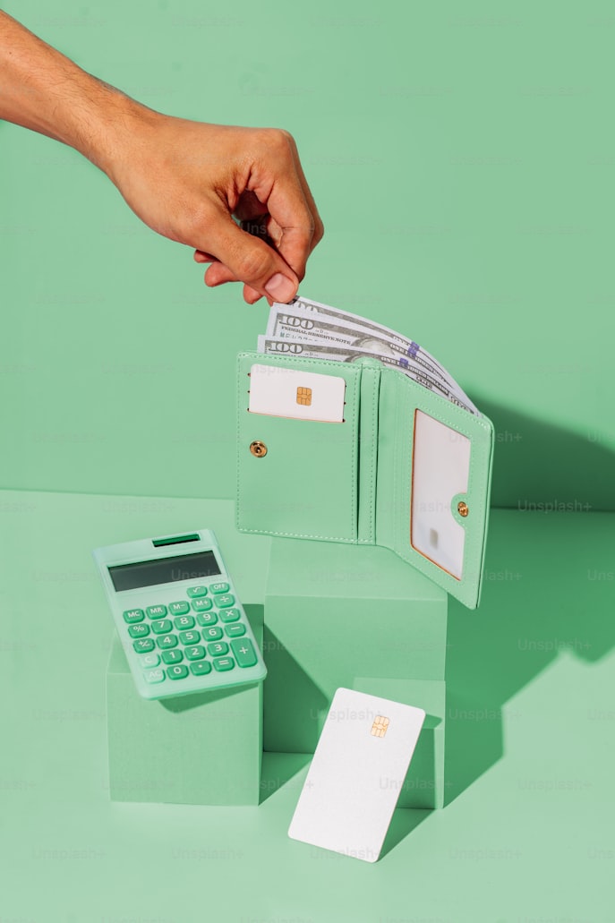Image is of wallet and calculator. Everything is mint green