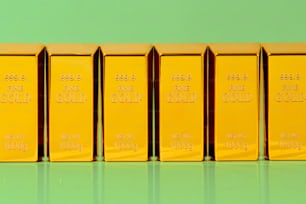 Una fila de lingotes de oro sentados encima de una mesa