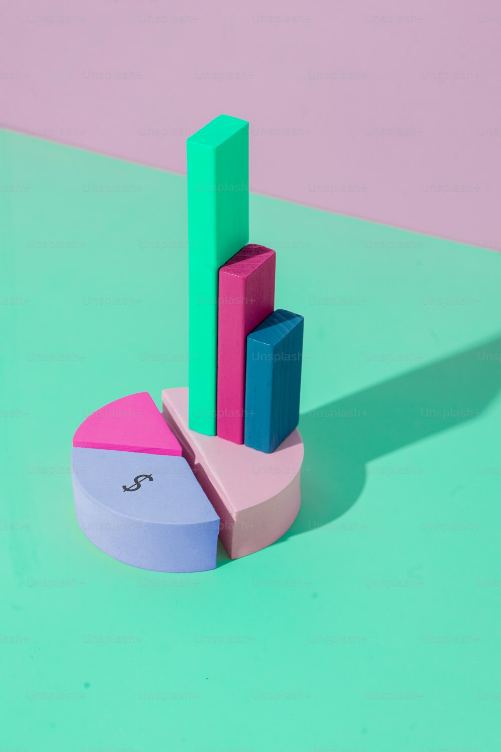 um objeto rosa, azul e verde em uma superfície verde