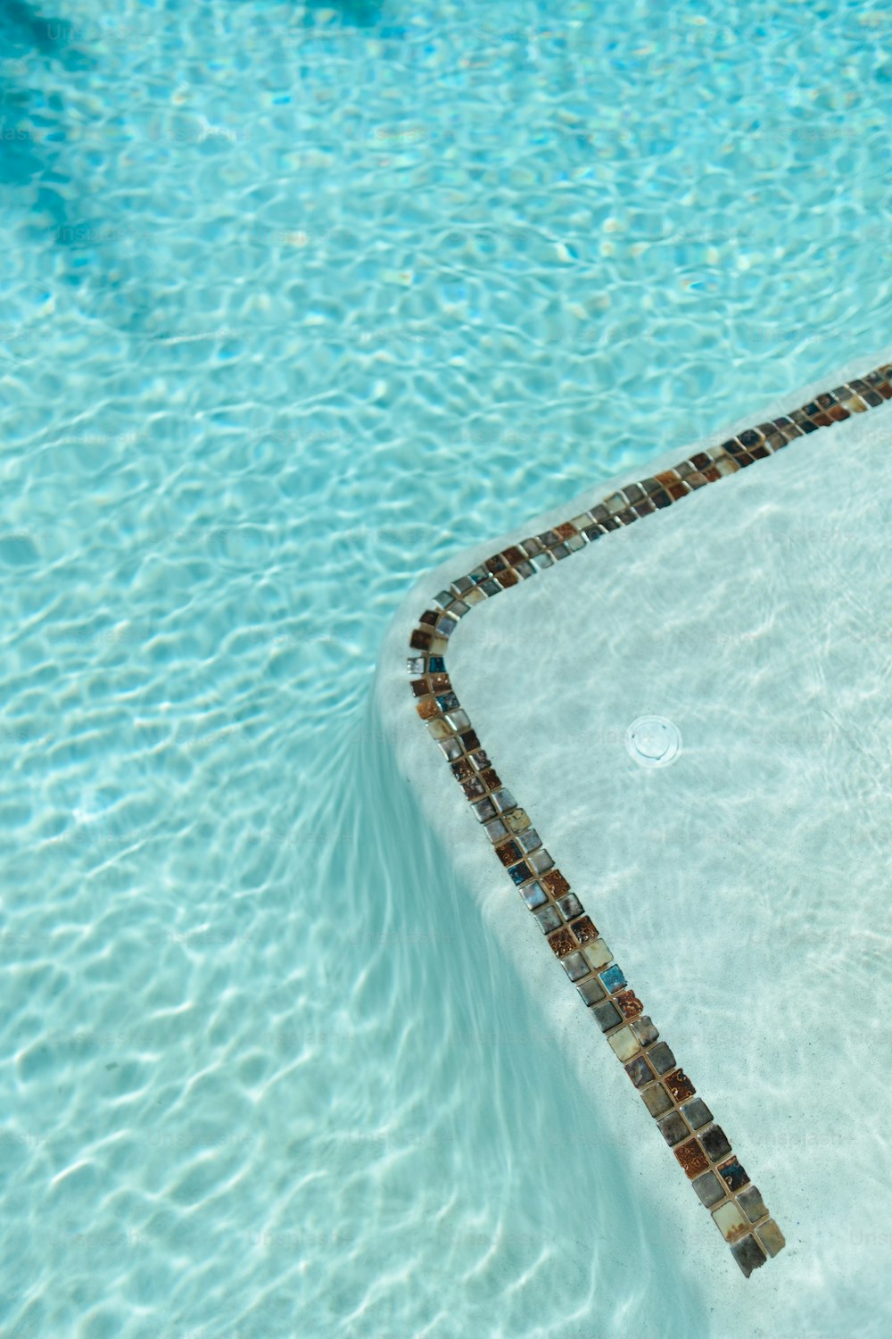 a swimming pool with a tiled edge and blue water