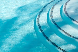 타일 가장자리와 푸른 물이있는 수영장