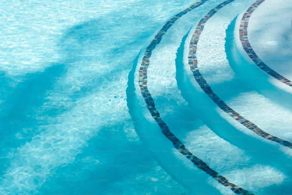 ein Schwimmbad mit gefliestem Rand und blauem Wasser