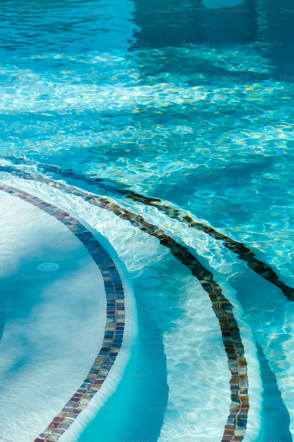 ein Pool mit blauem Wasser und einer kreisförmigen Fliesenumrandung