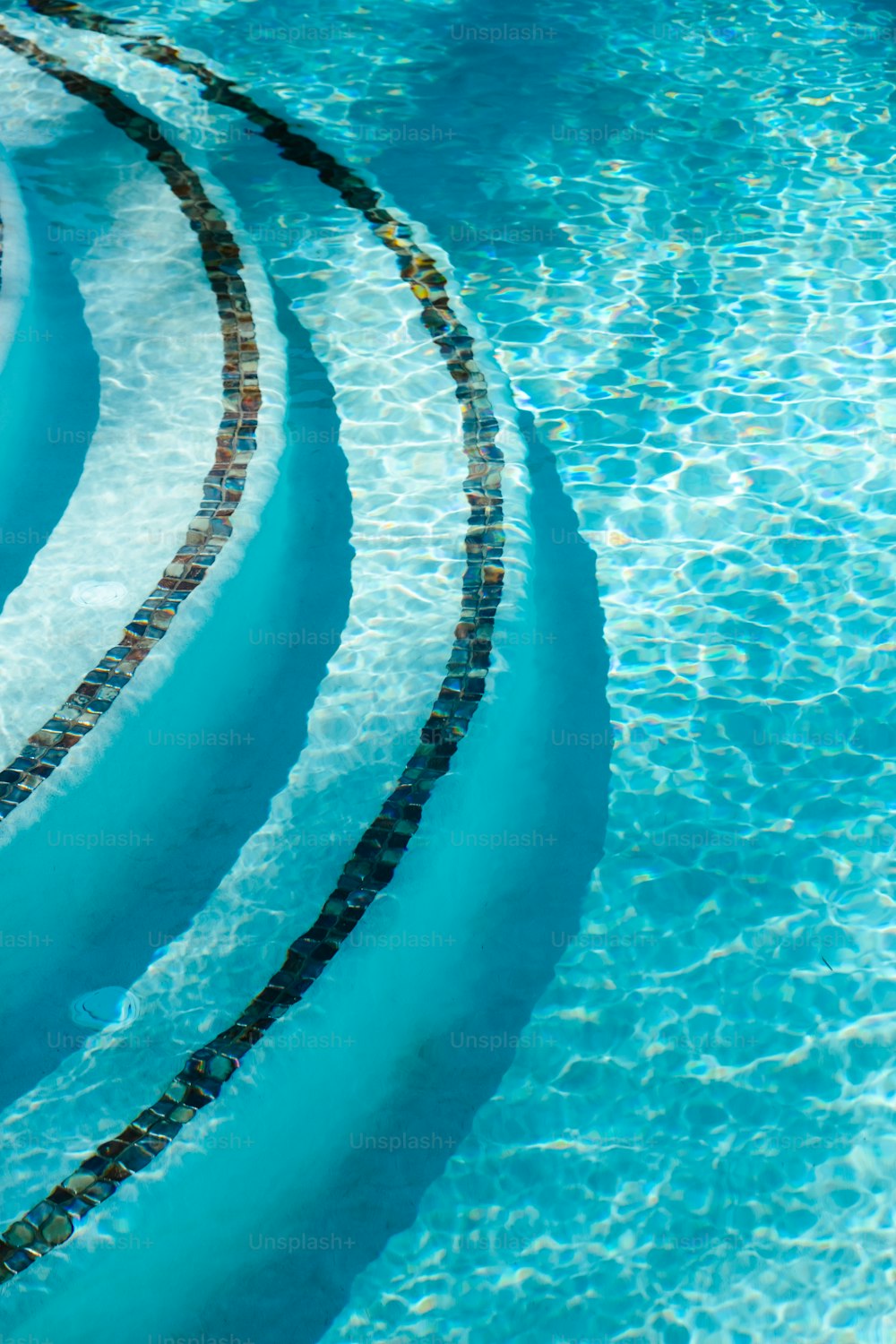 ein Pool mit blauem Wasser und einem spiralförmigen Design in der Mitte