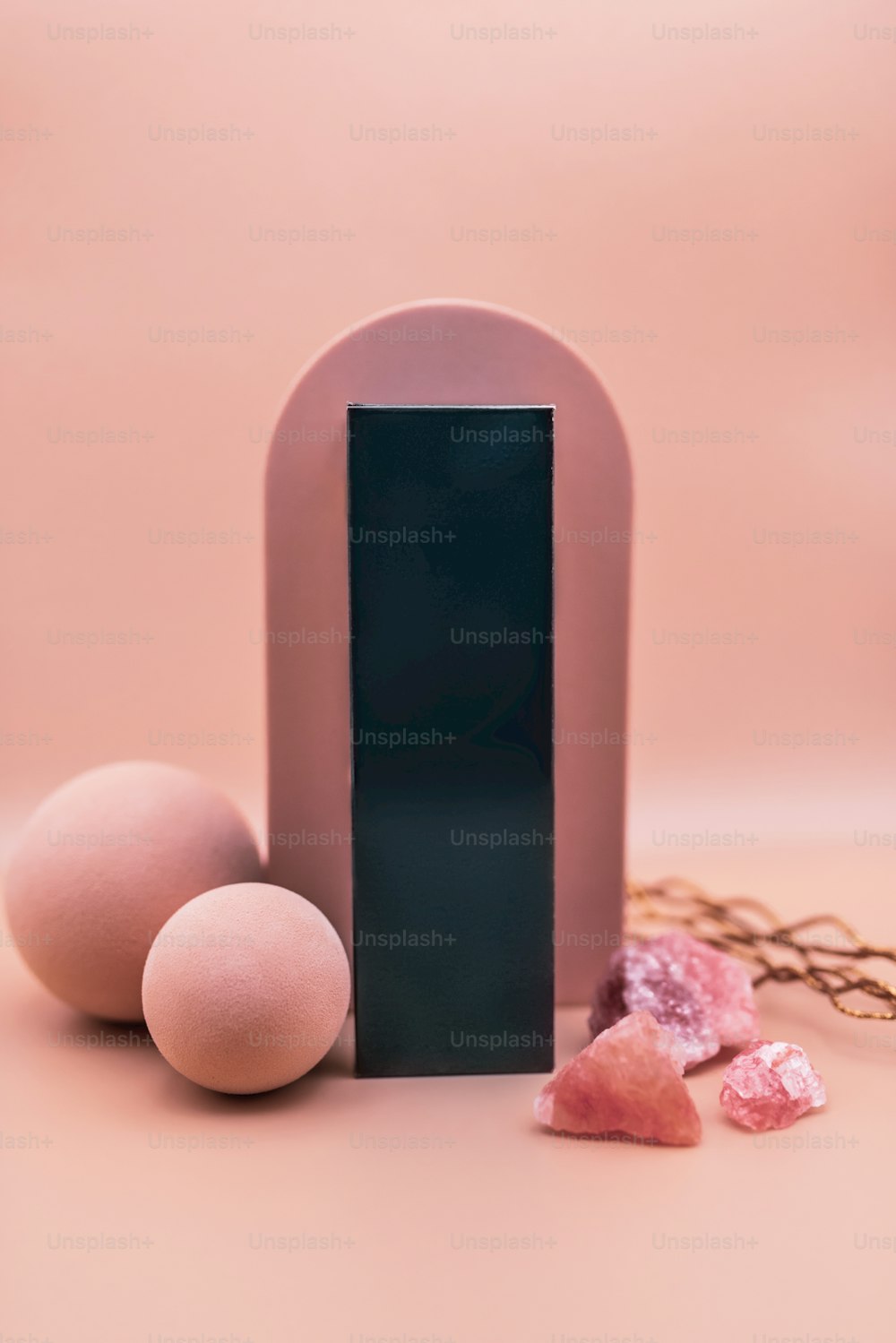 three eggs and a pink object on a pink background