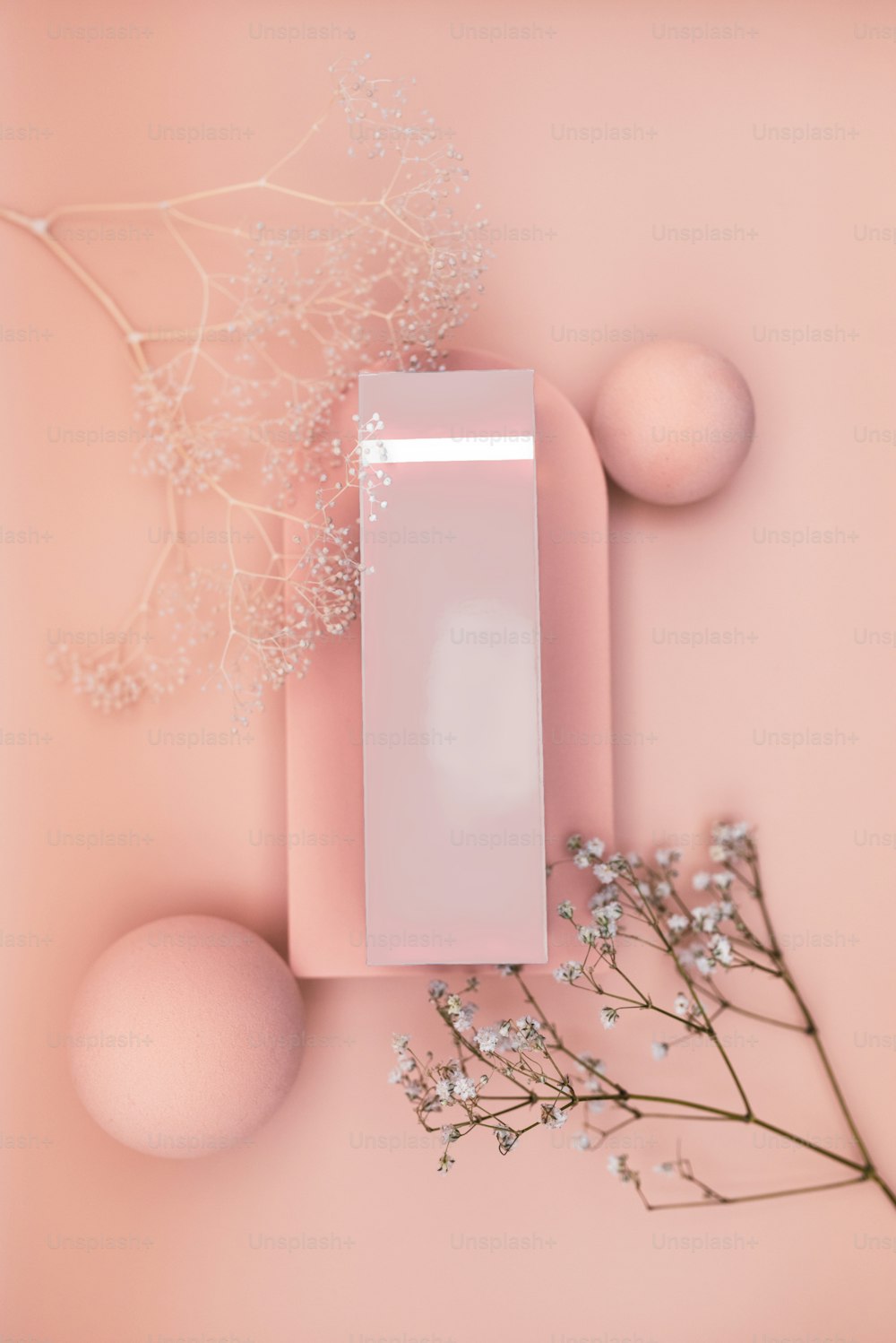 a pink box and some flowers on a pink surface