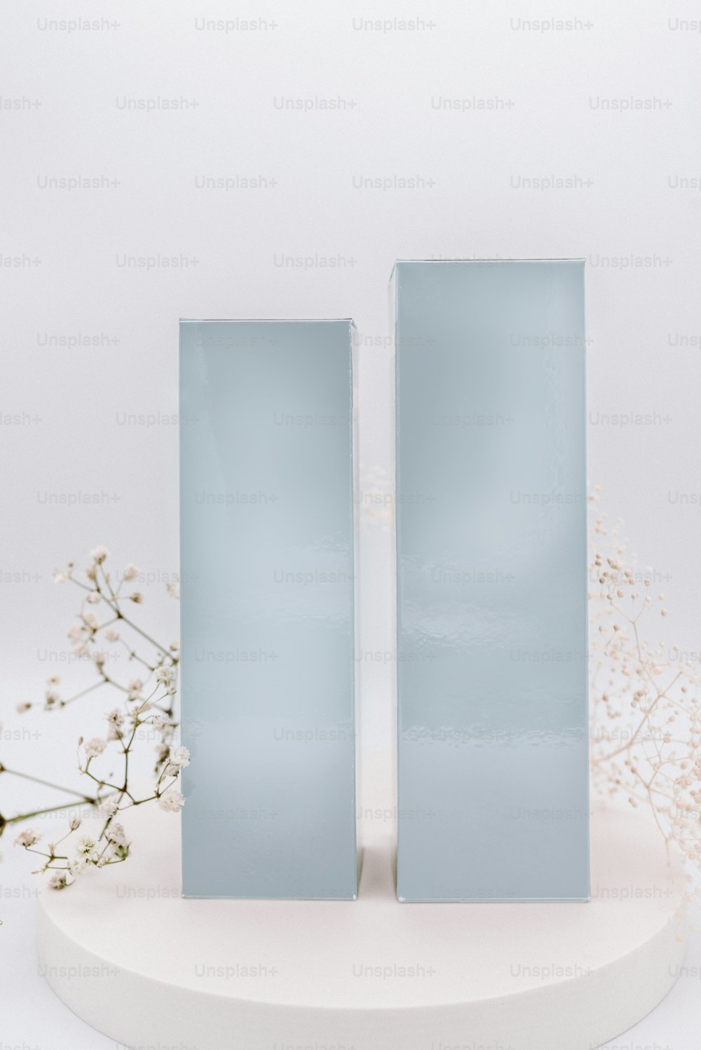a couple of white vases sitting on top of a white table