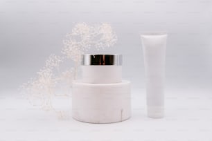 a white container with a silver lid next to a white container with a silver lid