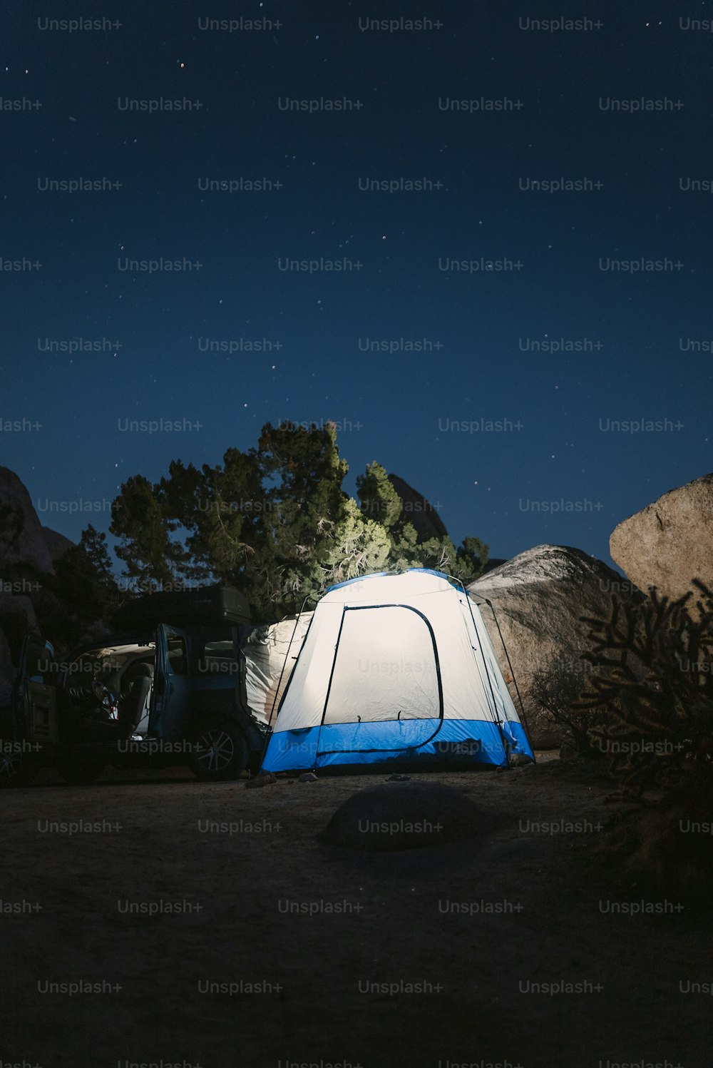 una tenda blu e bianca seduta in cima a un campo sporco