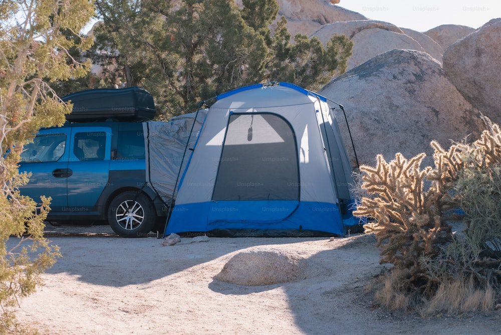 砂漠の真ん中に座っている青と灰色のテント