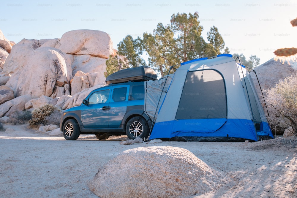 a van is parked next to a tent in the desert