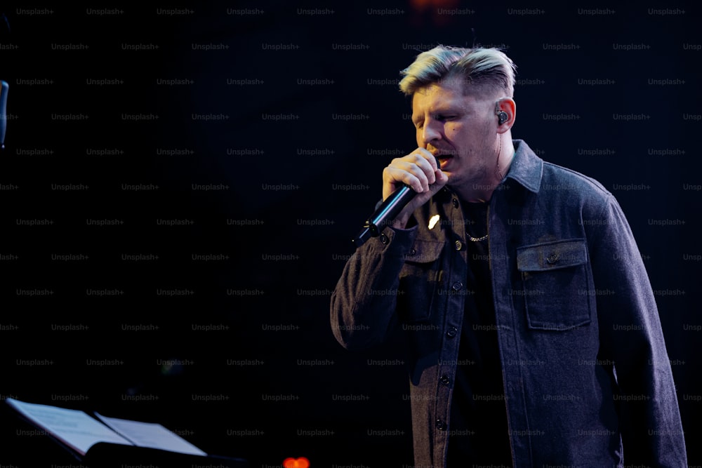um homem cantando em um microfone no palco