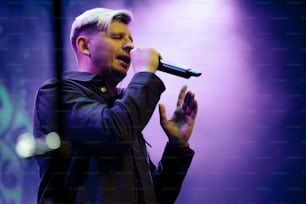 a man standing on a stage holding a microphone