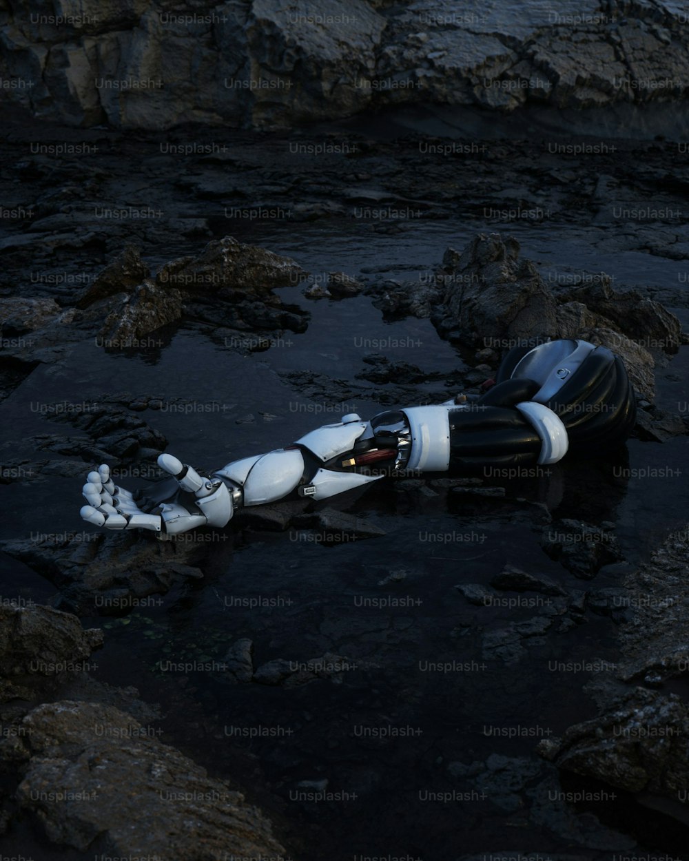 um robô está deitado sobre as rochas na água