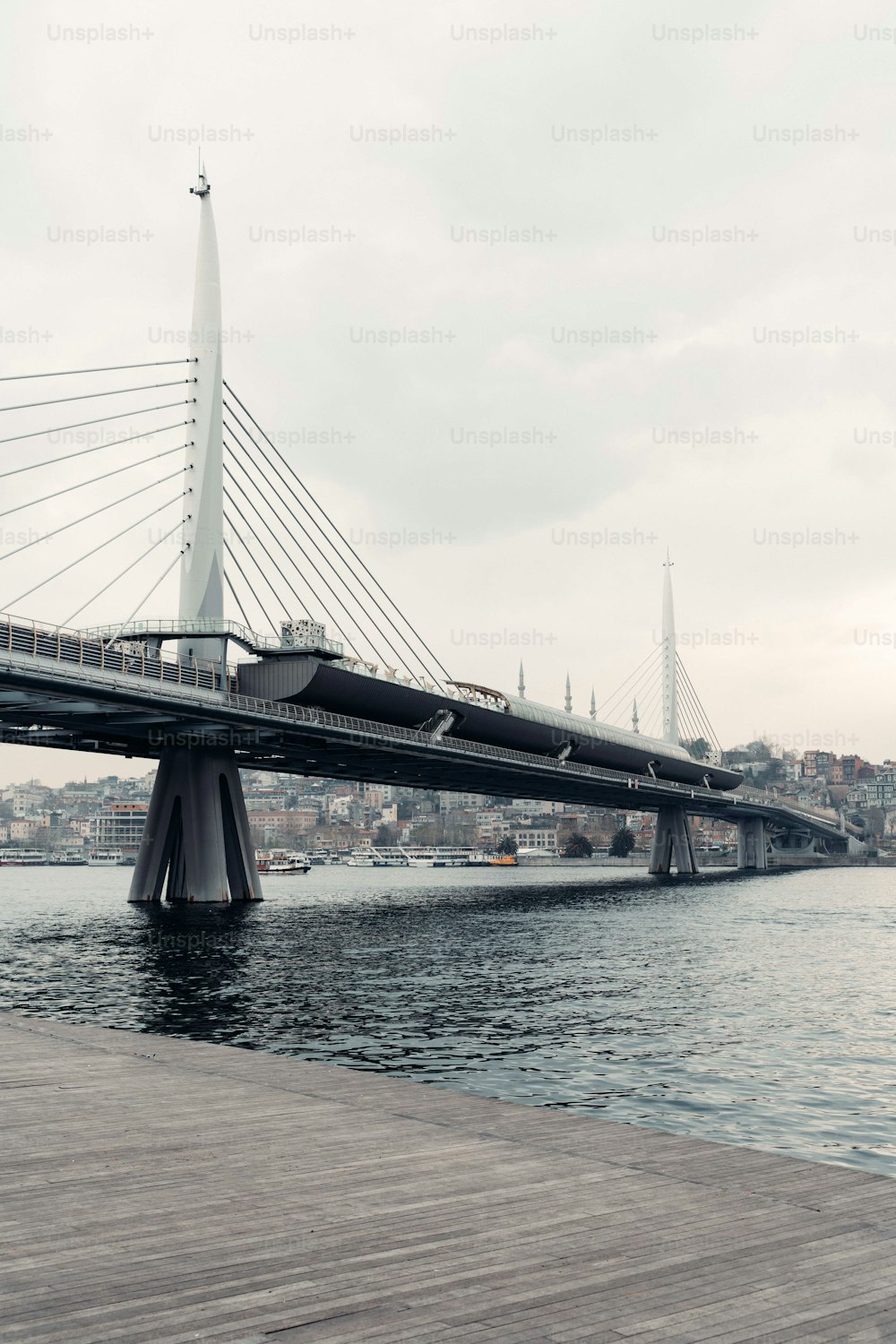 a bridge over a body of water with a city in the background