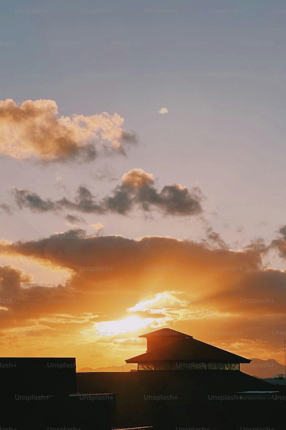 a plane flying in the sky at sunset