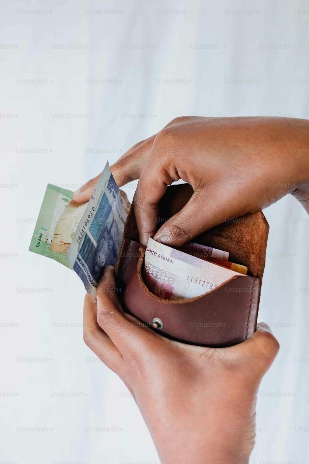 Eine Person, die Geld in eine Brieftasche steckt