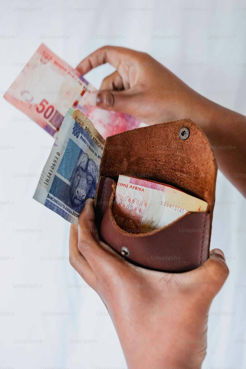 a person holding a wallet with money in it
