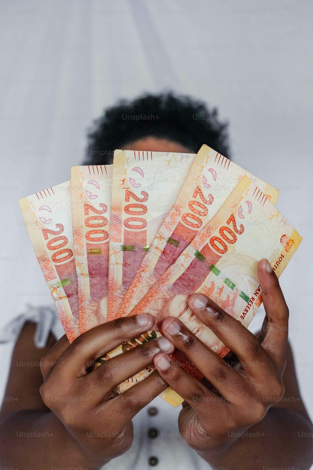 Una mujer sosteniendo un montón de dinero en sus manos