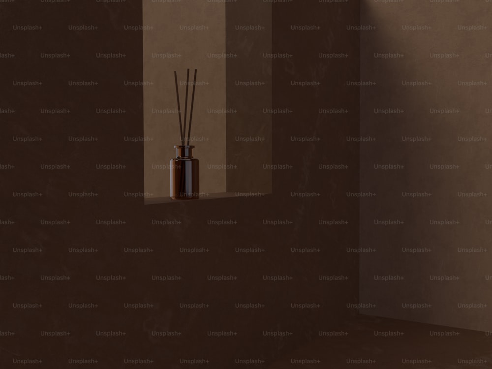 a room with a brown wall and a brown vase with reeds in it