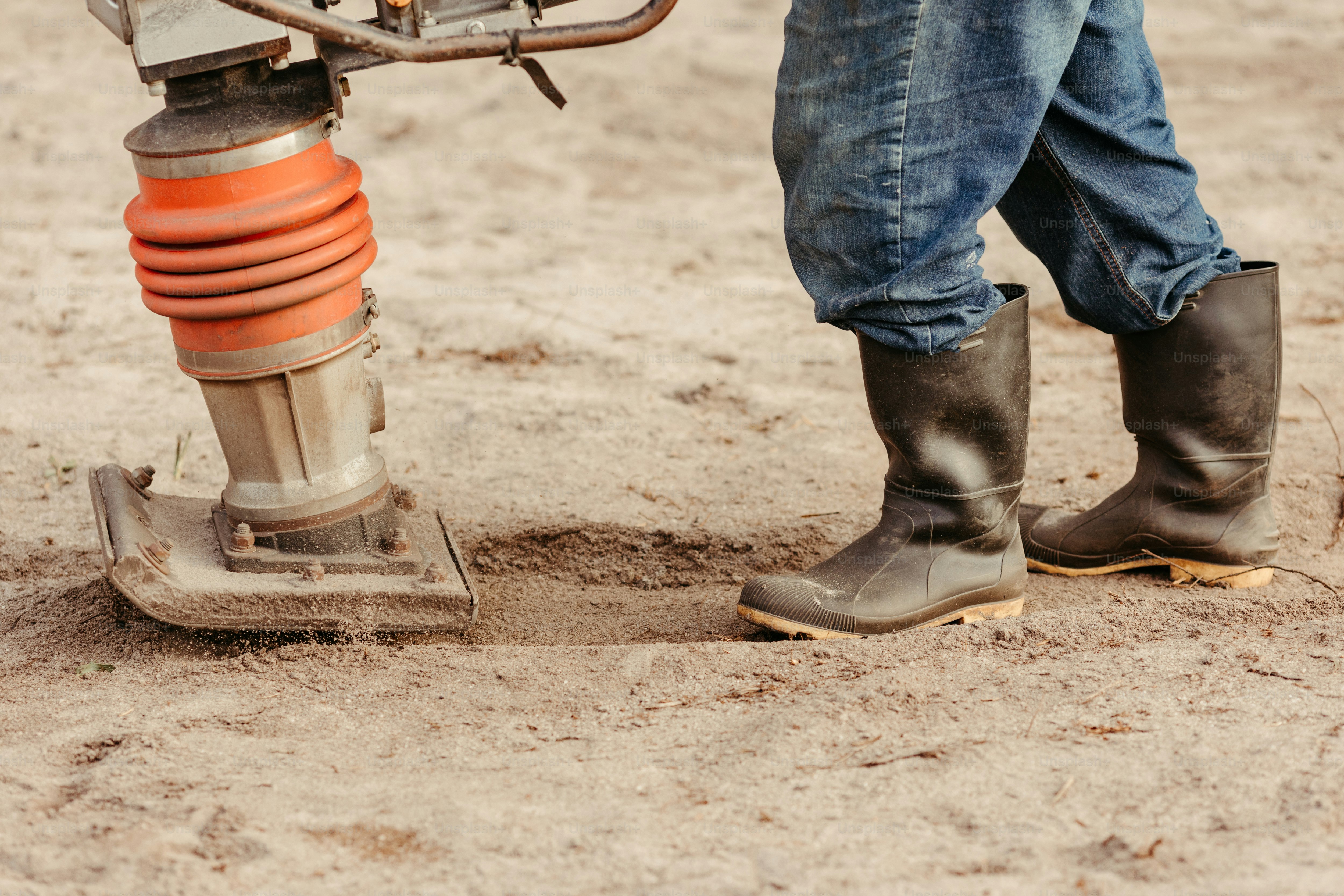 a person standing next to a machine in the dirt