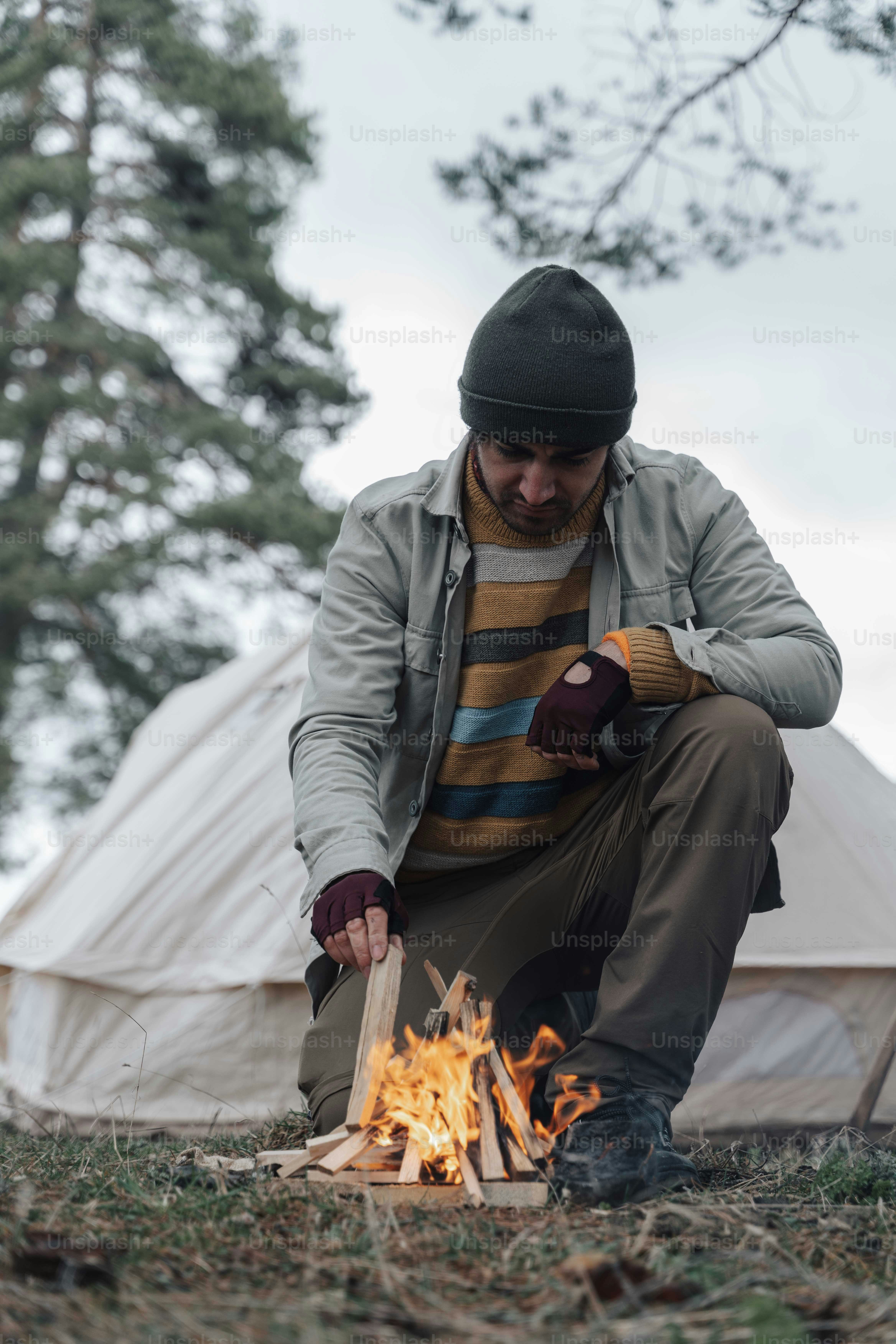 a man sitting in front of a campfire