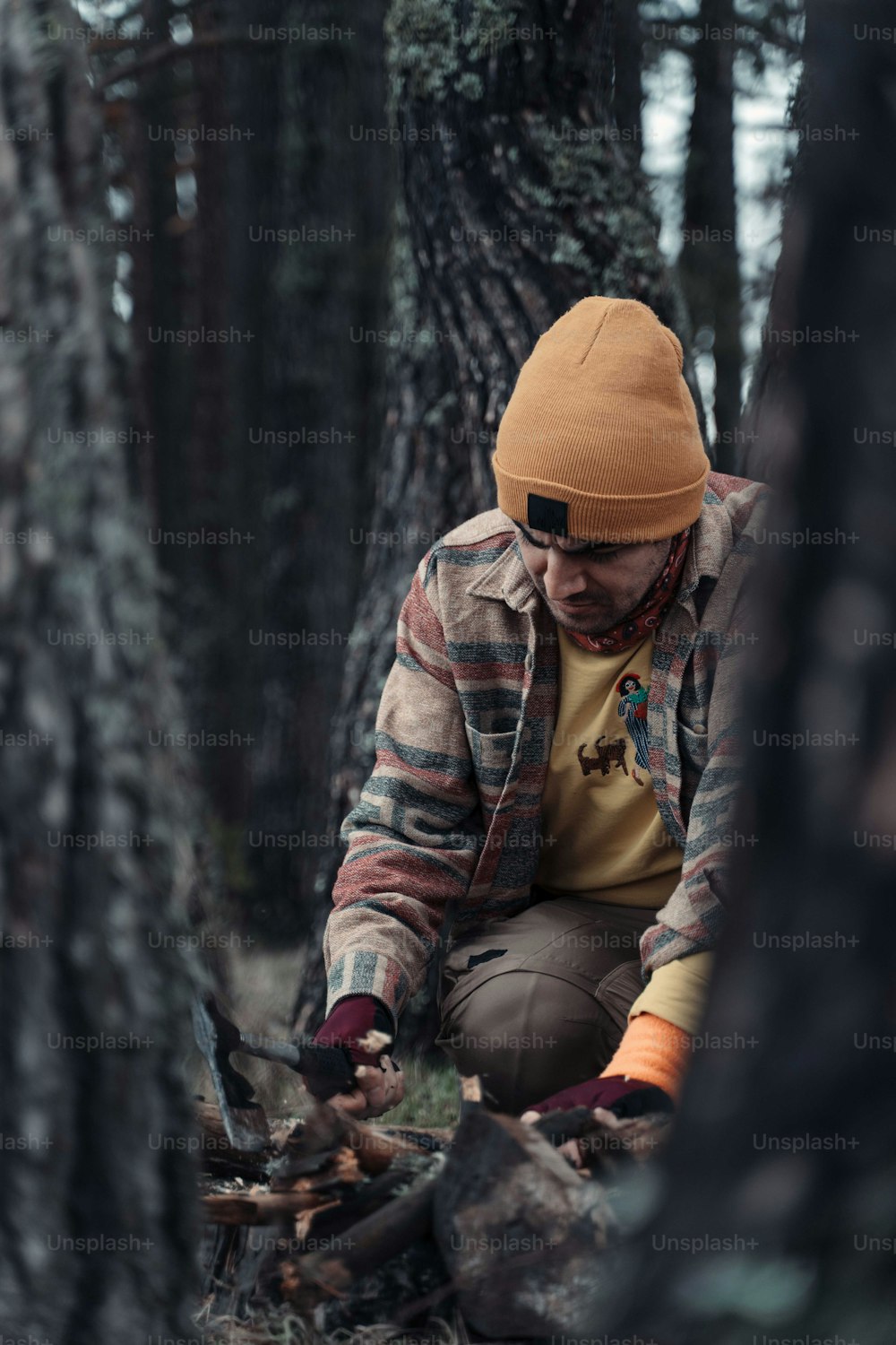 a man sitting on a tree stump in the woods