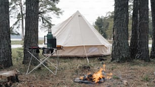 une tente est installée à côté d’un feu de camp