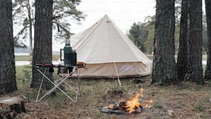 a tent is set up next to a campfire