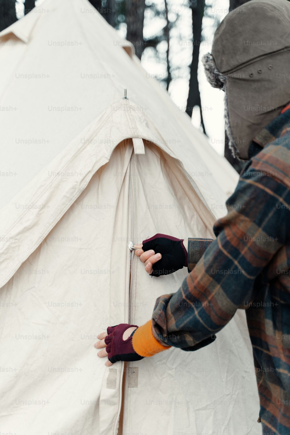 a person wearing gloves putting something in a tent