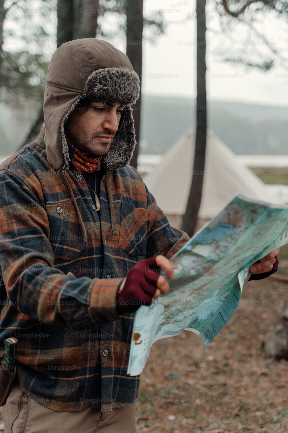 um homem segurando um mapa na floresta