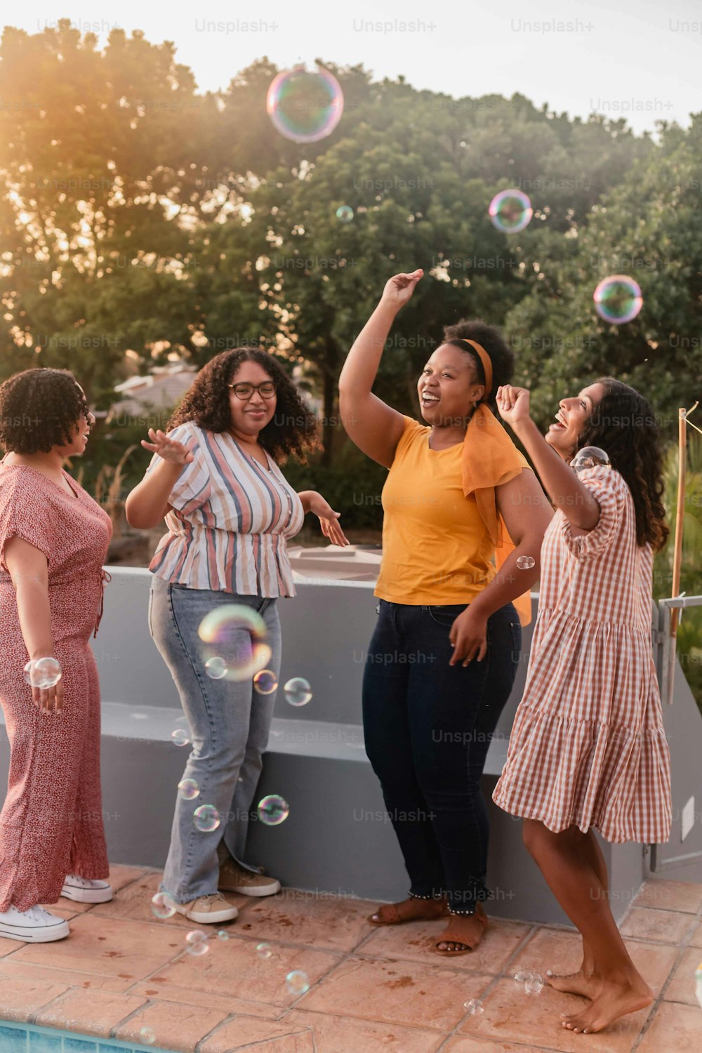 a group of women standing next to a swimming pool