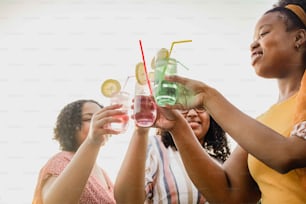 a group of women standing next to each other holding wine glasses