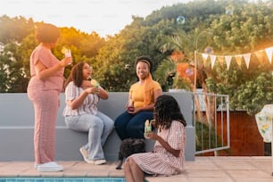 a group of women sitting next to a swimming pool