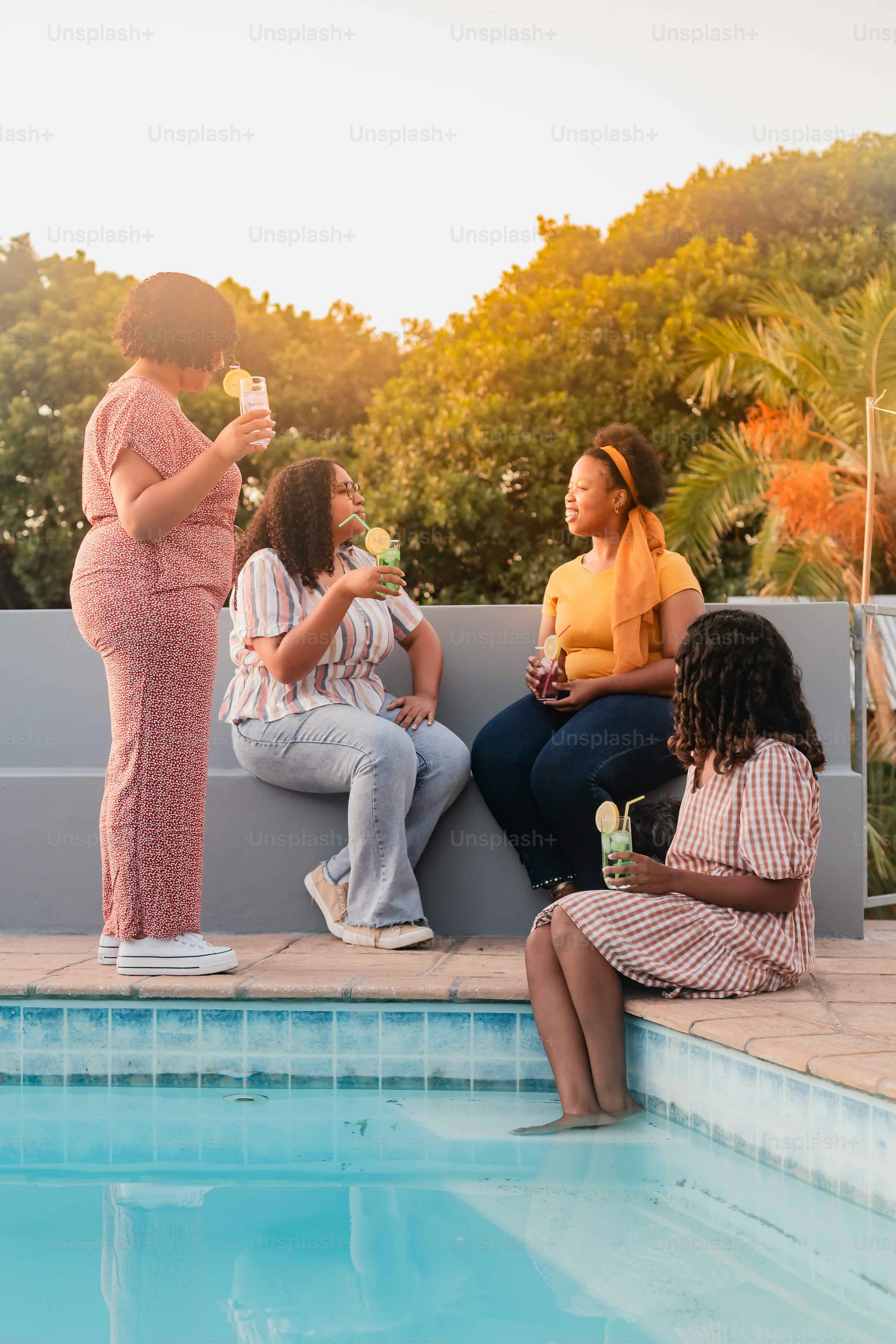 a group of women sitting next to a swimming pool