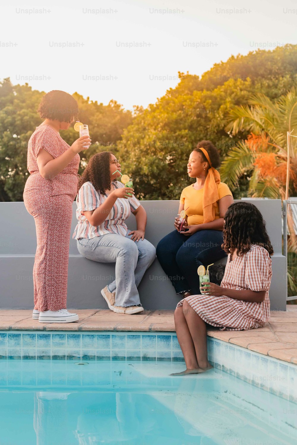 um grupo de mulheres sentadas ao lado de uma piscina