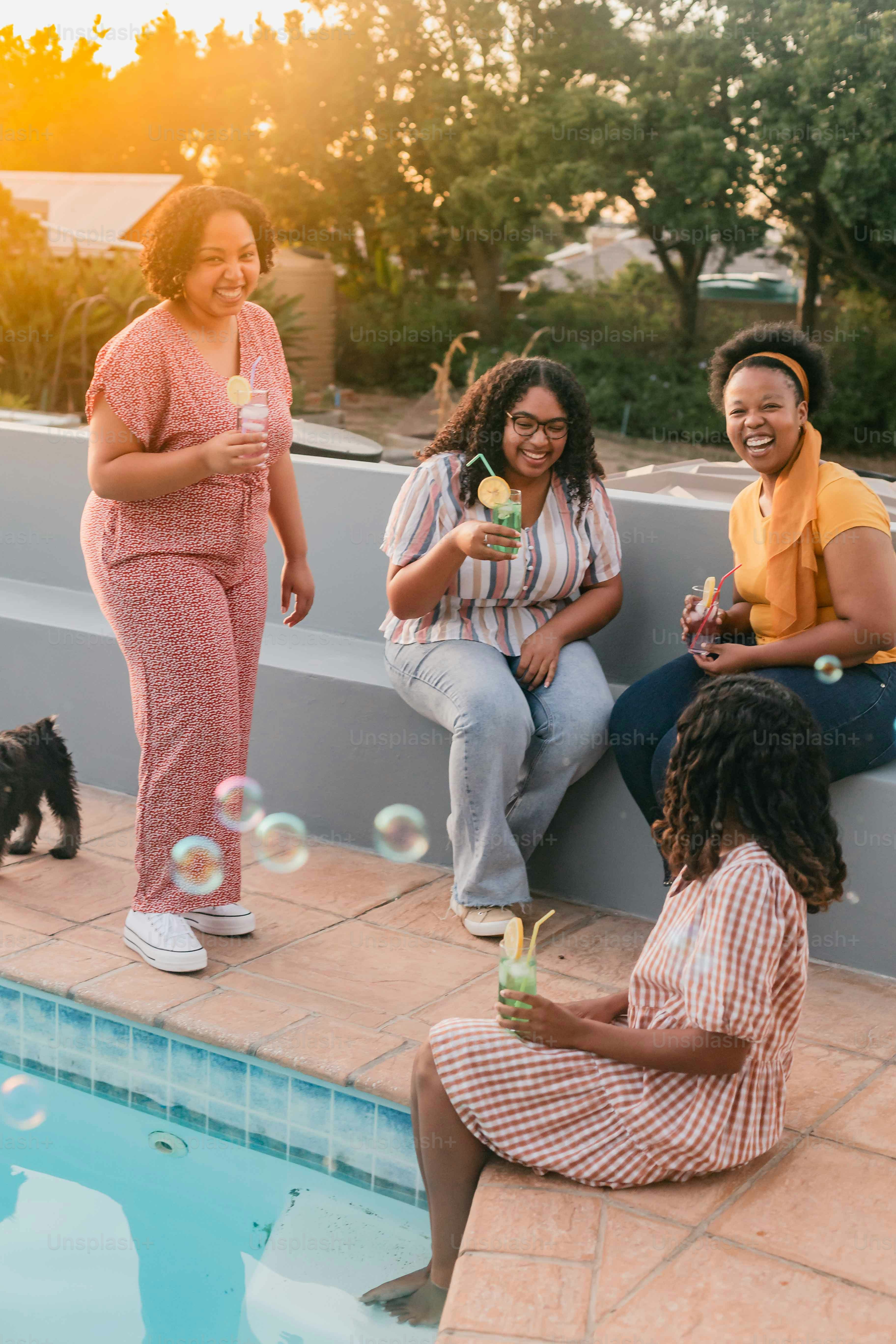 a group of people sitting next to a swimming pool