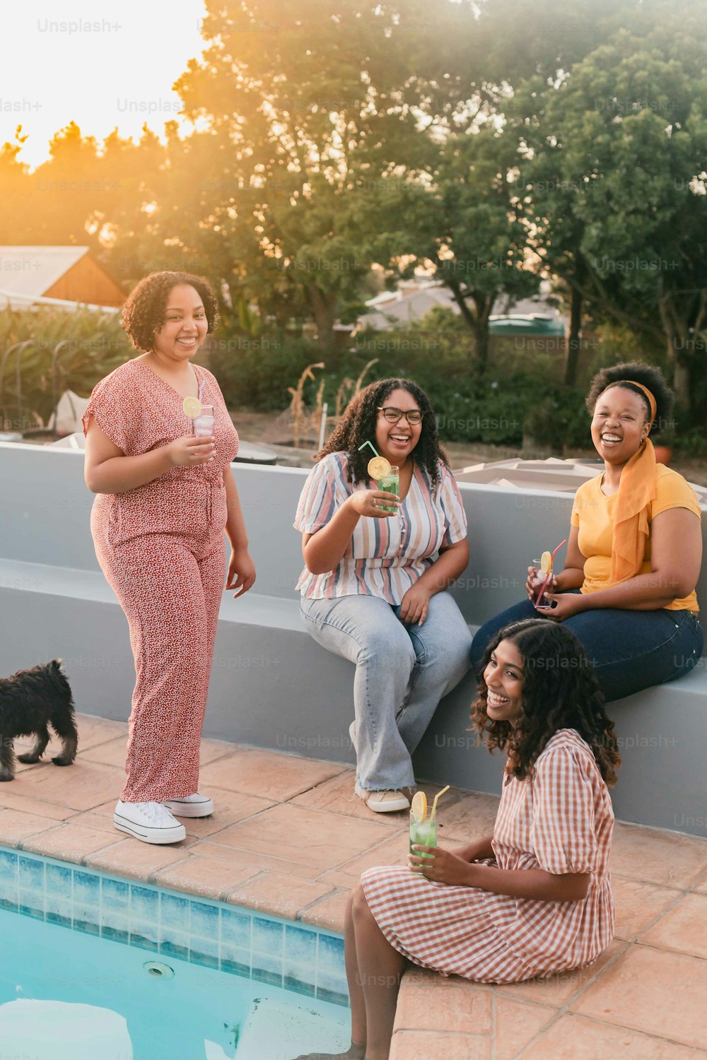 a group of women sitting next to a swimming pool